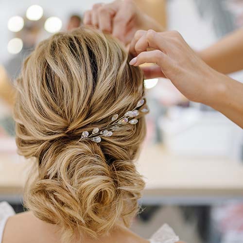 Hairdresser woman weaving braid hair, wedding styling.